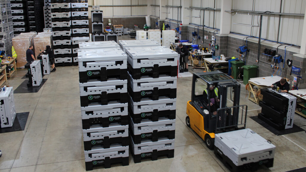 ALLpaQ's production workshop floor with a few of their containers stacked and folded. 