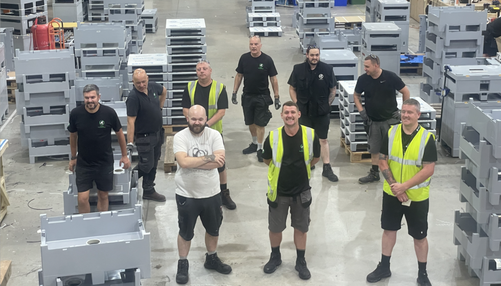 The ALLpaQ Production Team on the shop floor, with ALLpaQ 250L containers around them 